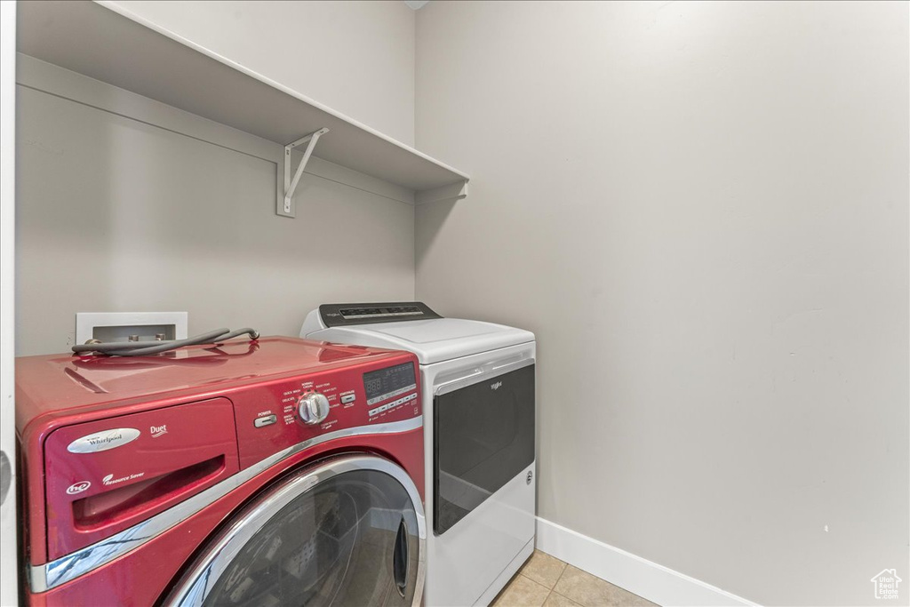 Laundry room featuring hookup for a washing machine, washing machine and dryer, and light tile floors