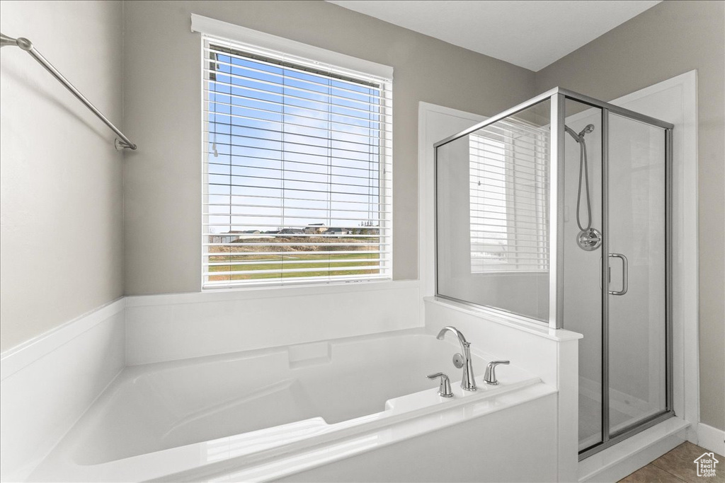 Bathroom with shower with separate bathtub, tile floors, and a wealth of natural light
