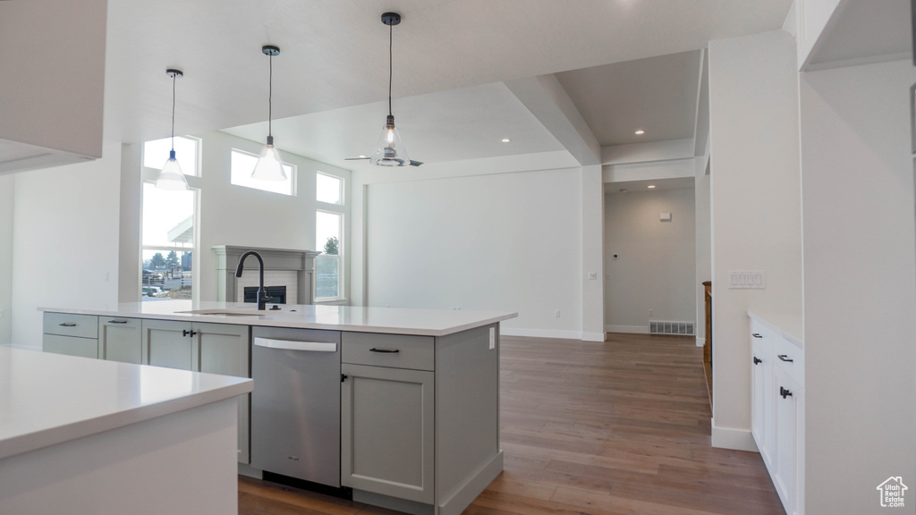 Kitchen featuring hanging light fixtures, sink, hardwood / wood-style flooring, and dishwasher
