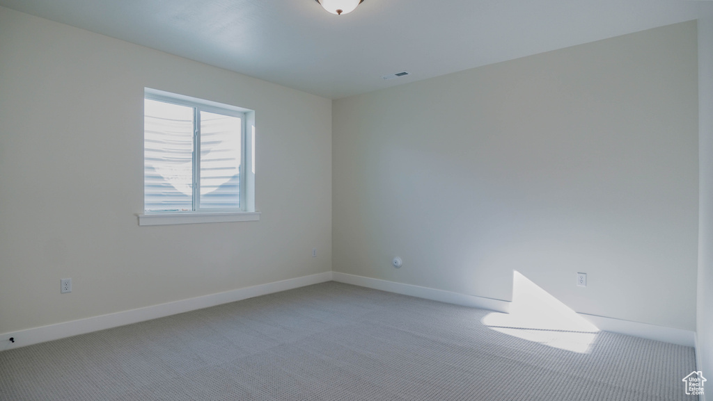 Spare room featuring light carpet