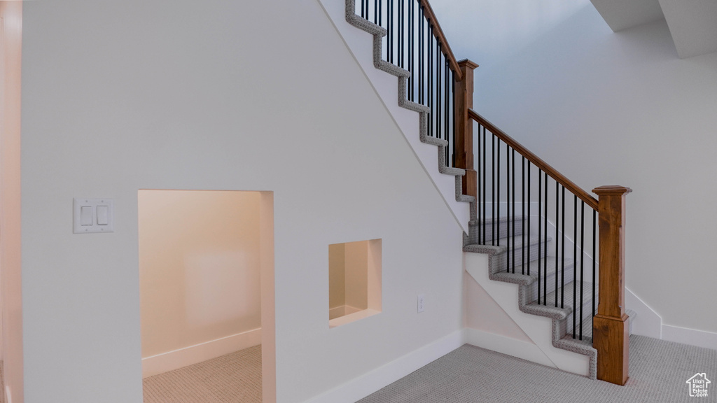 Stairs featuring light colored carpet