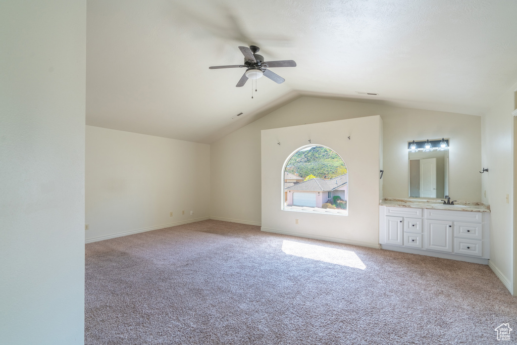 Unfurnished room with vaulted ceiling, light colored carpet, ceiling fan, and sink