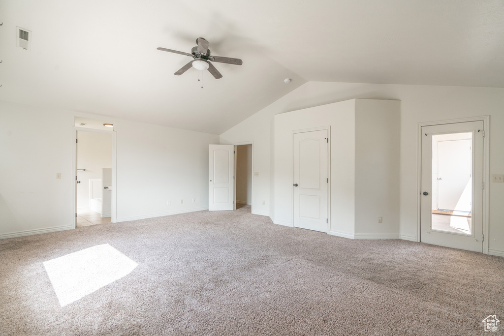 Interior space featuring lofted ceiling, light colored carpet, and ceiling fan