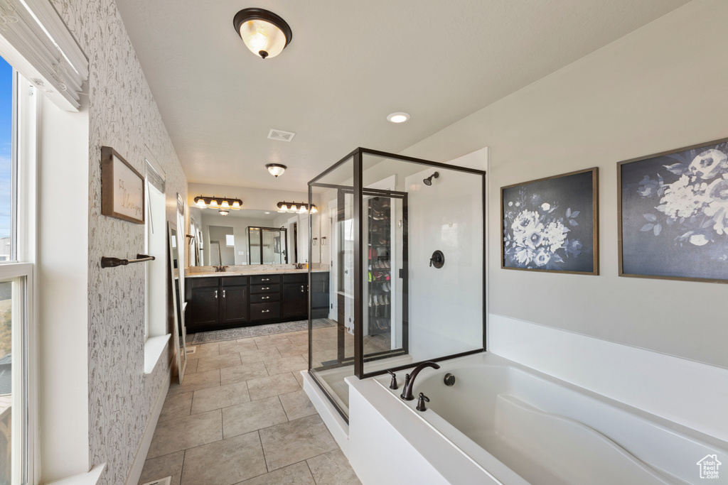Bathroom featuring vanity, plus walk in shower, and tile floors