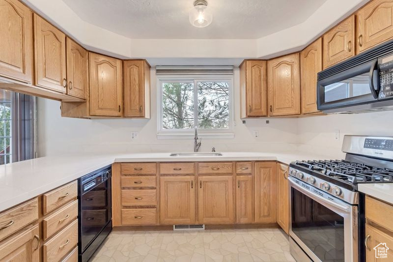 Kitchen with stainless steel range with gas cooktop, light tile floors, and sink
