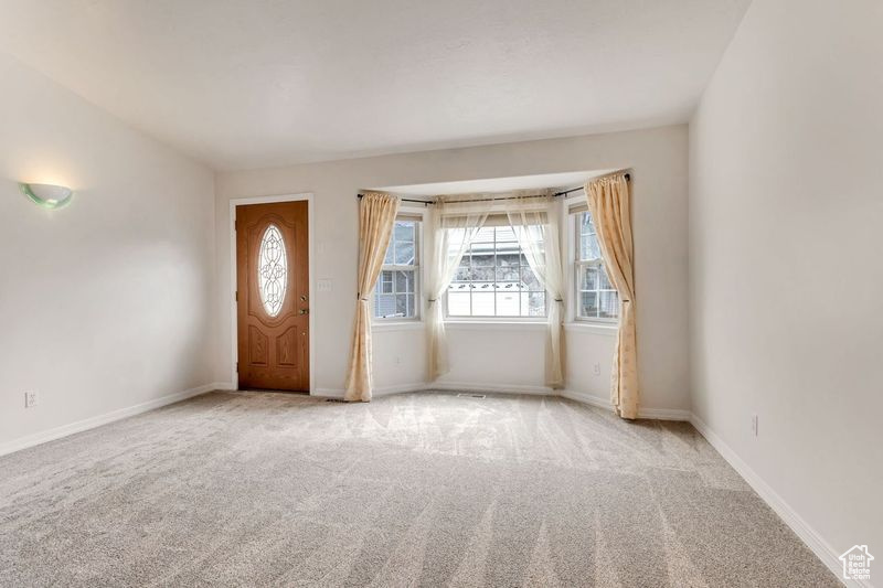 Entrance foyer with light colored carpet