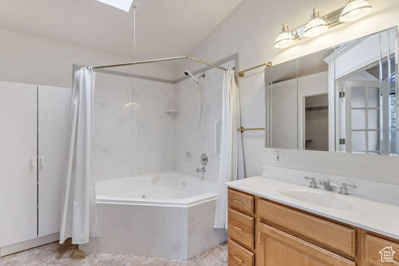 Bathroom with vanity, tile floors, and shower / bath combo with shower curtain