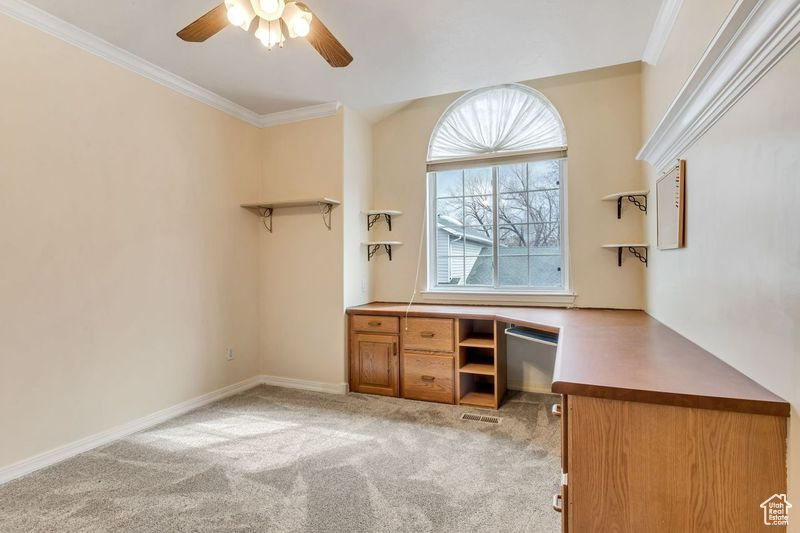 Unfurnished office featuring ornamental molding, light colored carpet, and ceiling fan