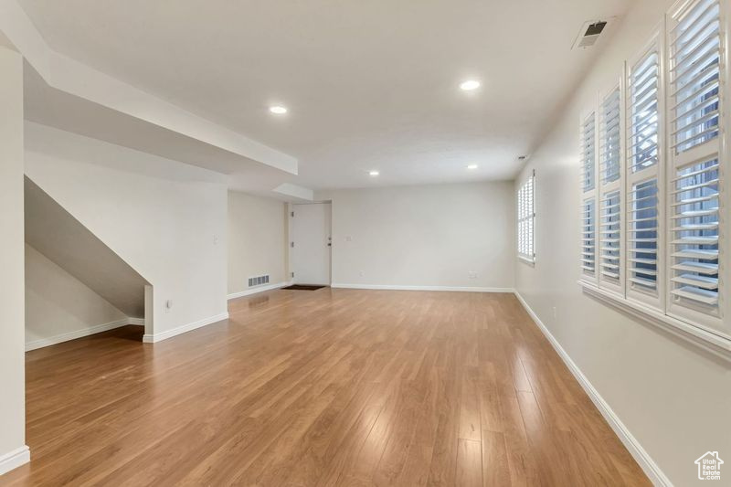 Empty room with plenty of natural light and light hardwood / wood-style floors