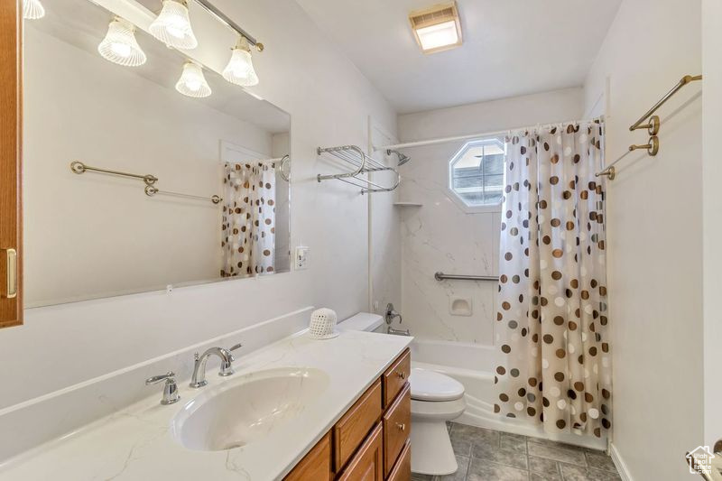 Full bathroom featuring shower / tub combo, vanity, tile flooring, and toilet