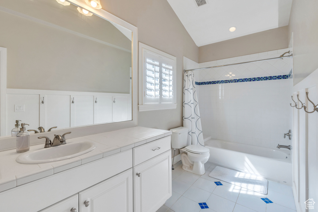 Full bathroom with vanity, tile flooring, vaulted ceiling, and toilet