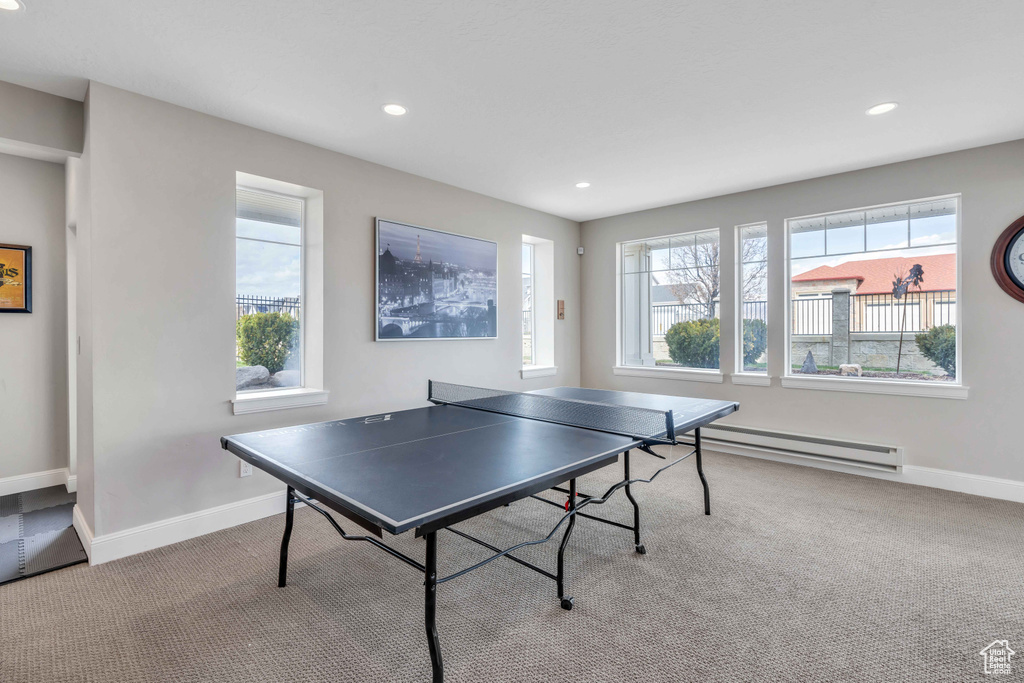 Rec room featuring plenty of natural light, light colored carpet, and a baseboard heating unit