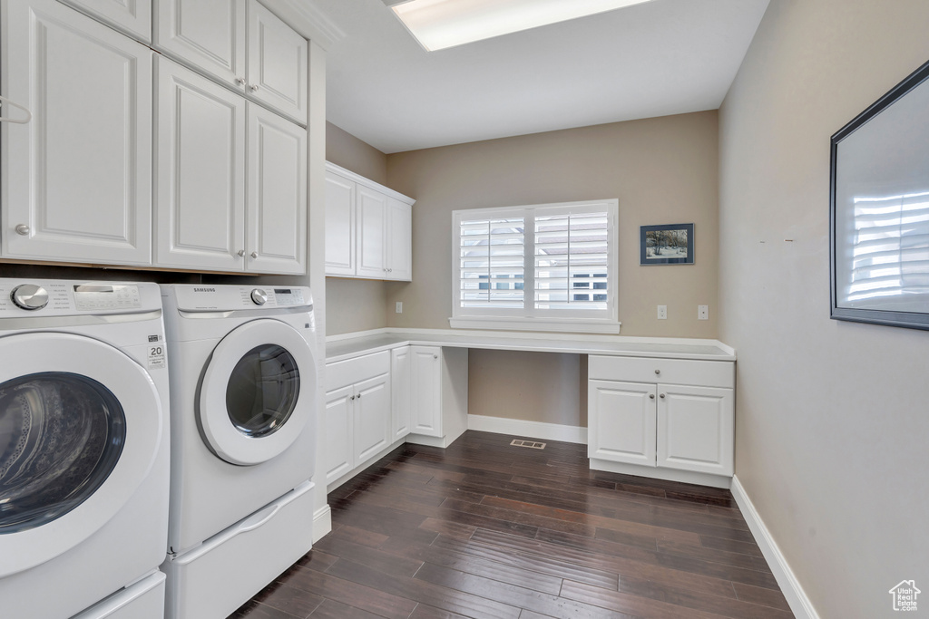 Laundry area featuring cabinets, dark hardwood / wood-style floors, and washer and dryer