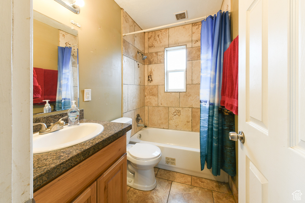 Full bathroom featuring tile floors, oversized vanity, toilet, and shower / bathtub combination with curtain