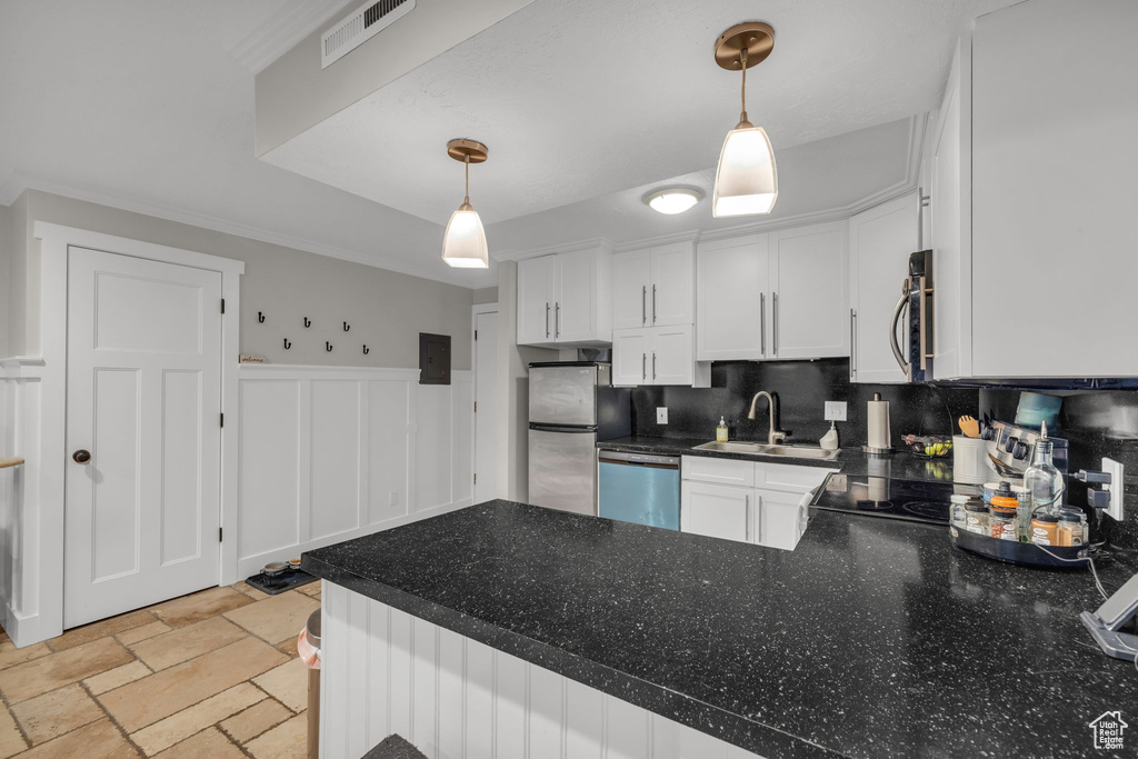 Kitchen with decorative light fixtures, backsplash, appliances with stainless steel finishes, sink, and light tile floors