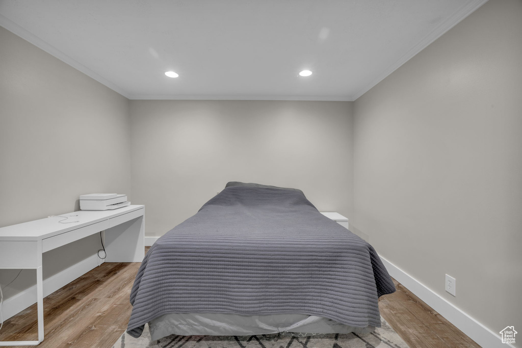 Bedroom featuring crown molding and light hardwood / wood-style flooring