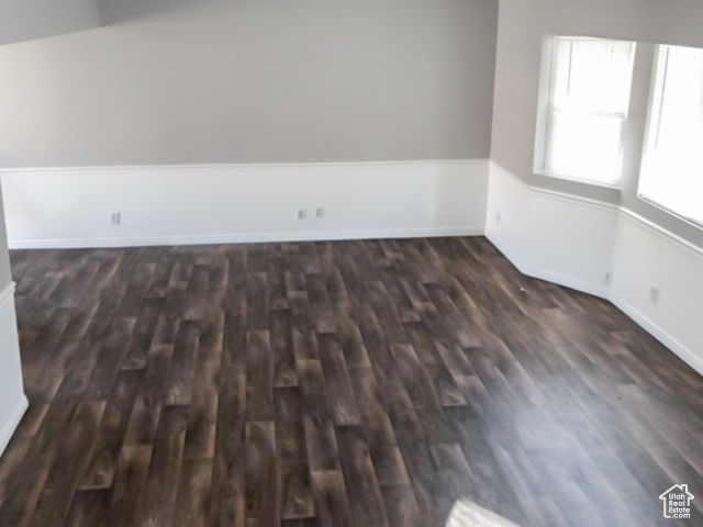 Spare room featuring dark wood-type flooring