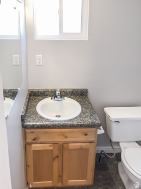 Bathroom with toilet, tile flooring, and vanity