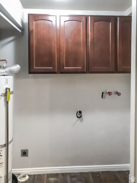 Laundry room featuring electric dryer hookup, hardwood / wood-style floors, cabinets, and water heater