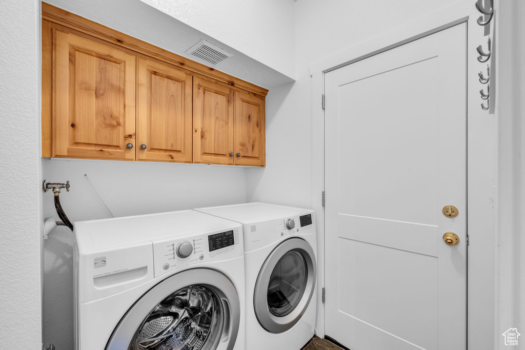 Laundry room featuring washer hookup, cabinets, and separate washer and dryer