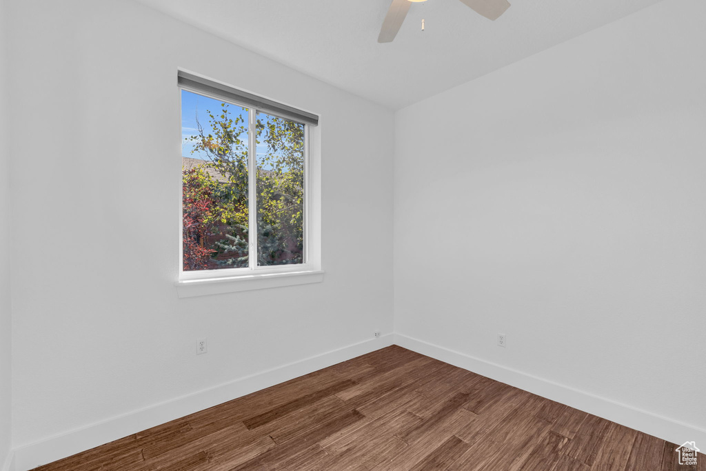 Spare room with ceiling fan and dark wood-type flooring