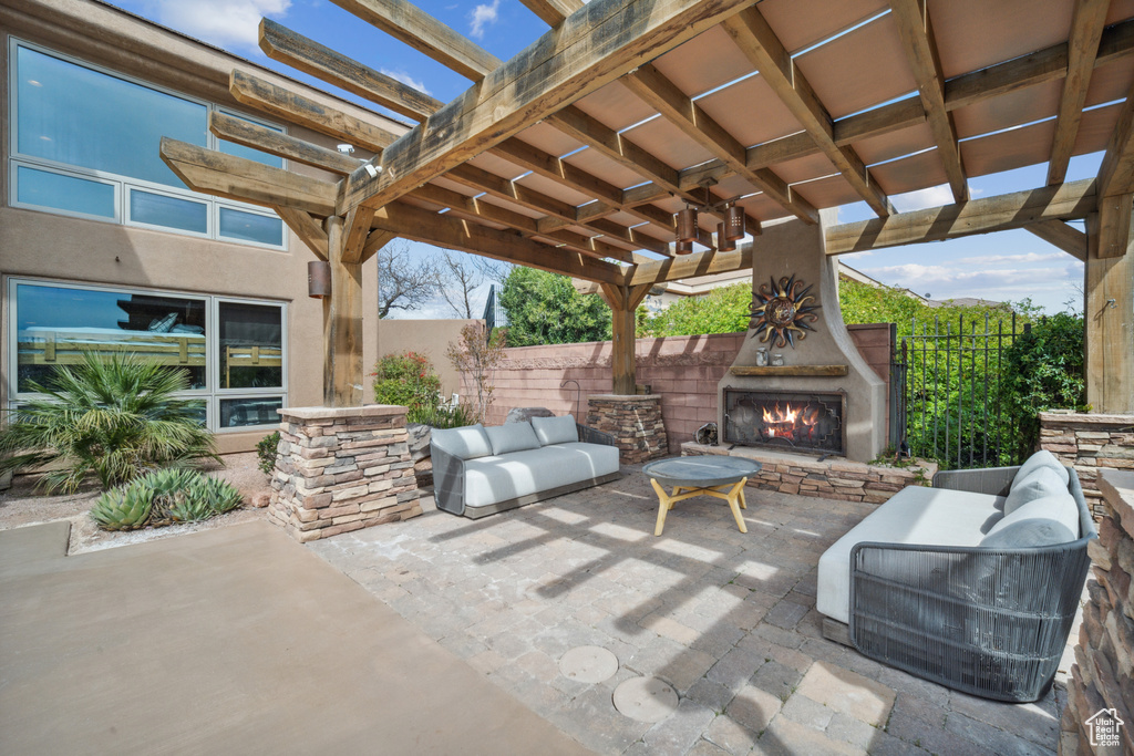 View of patio / terrace featuring an outdoor stone fireplace and a pergola