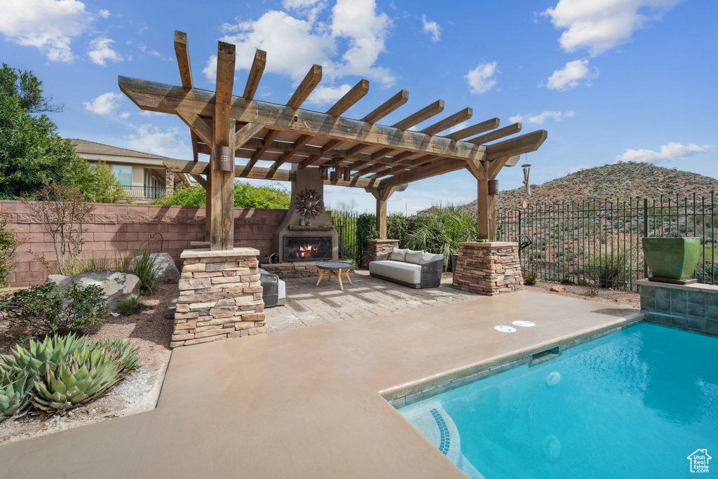 View of pool featuring a pergola, a patio area, a mountain view, and an outdoor living space