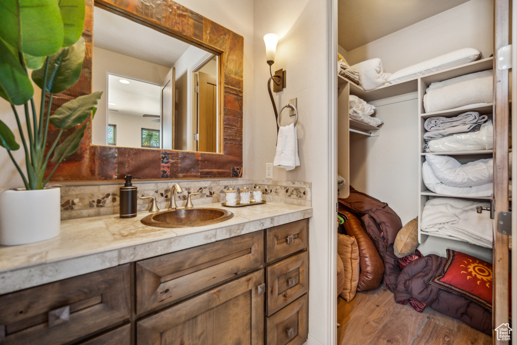 Bathroom featuring vanity, backsplash, and wood-type flooring
