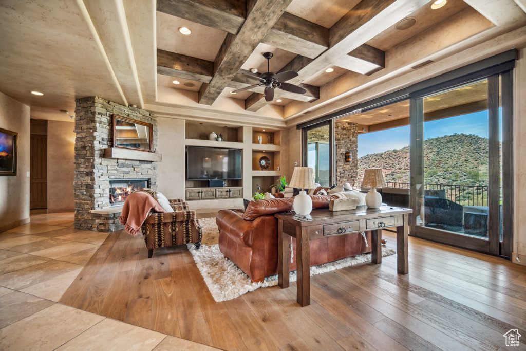 Living room with a wealth of natural light, a mountain view, ceiling fan, and a fireplace