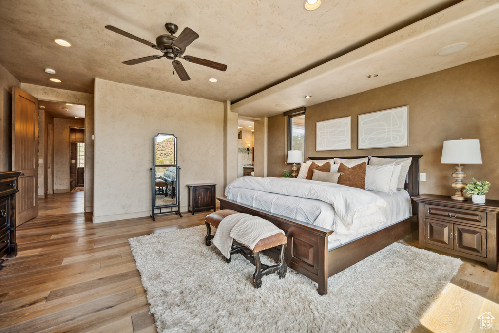 Bedroom with multiple windows, ceiling fan, and light hardwood / wood-style flooring