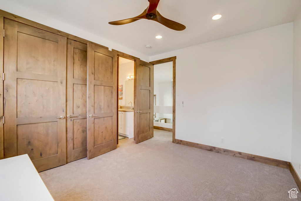 Unfurnished bedroom featuring light carpet and ceiling fan