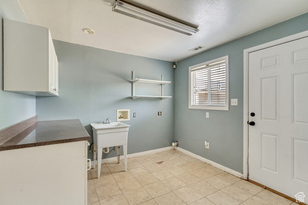 Laundry room featuring cabinets, hookup for a washing machine, and light tile patterned floors