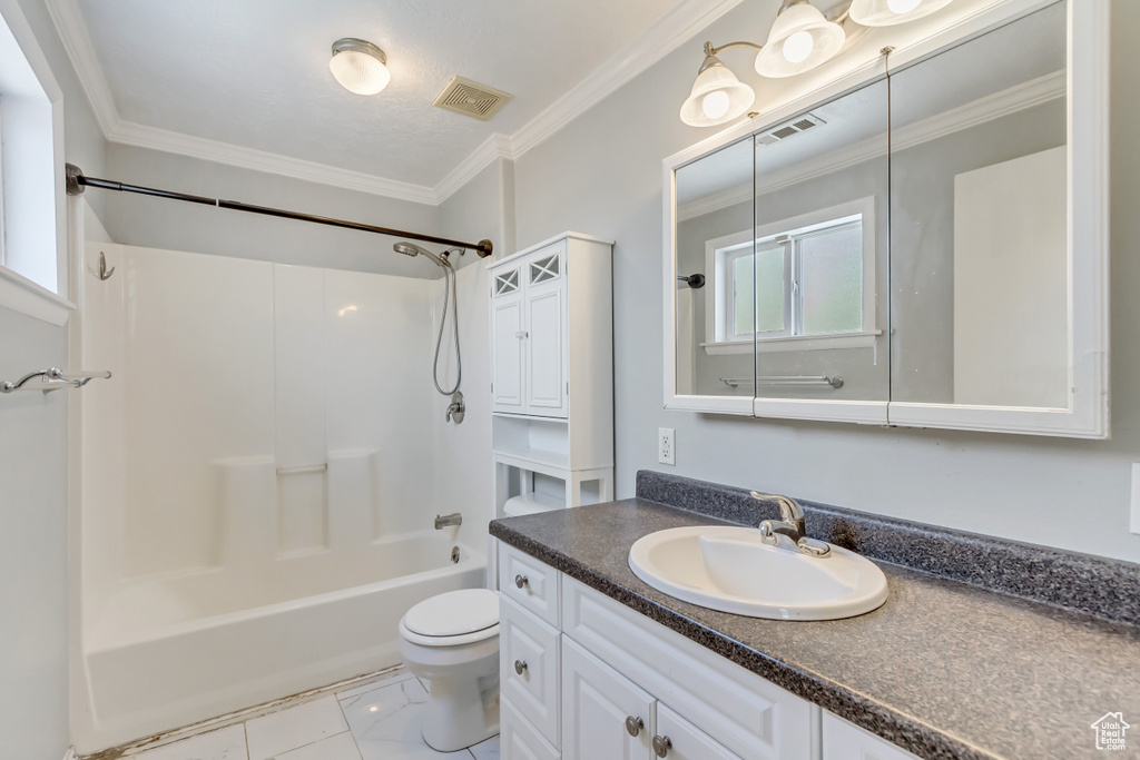 Full bathroom with tile patterned flooring, bathtub / shower combination, toilet, vanity, and ornamental molding