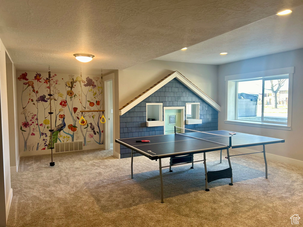 Game room with light carpet and a textured ceiling