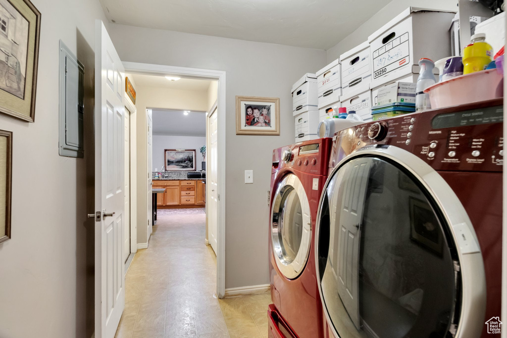 Clothes washing area with separate washer and dryer and light tile floors