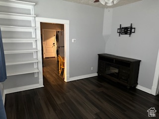 Interior space with ceiling fan and dark hardwood / wood-style floors
