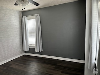 Spare room with ceiling fan and dark hardwood / wood-style floors