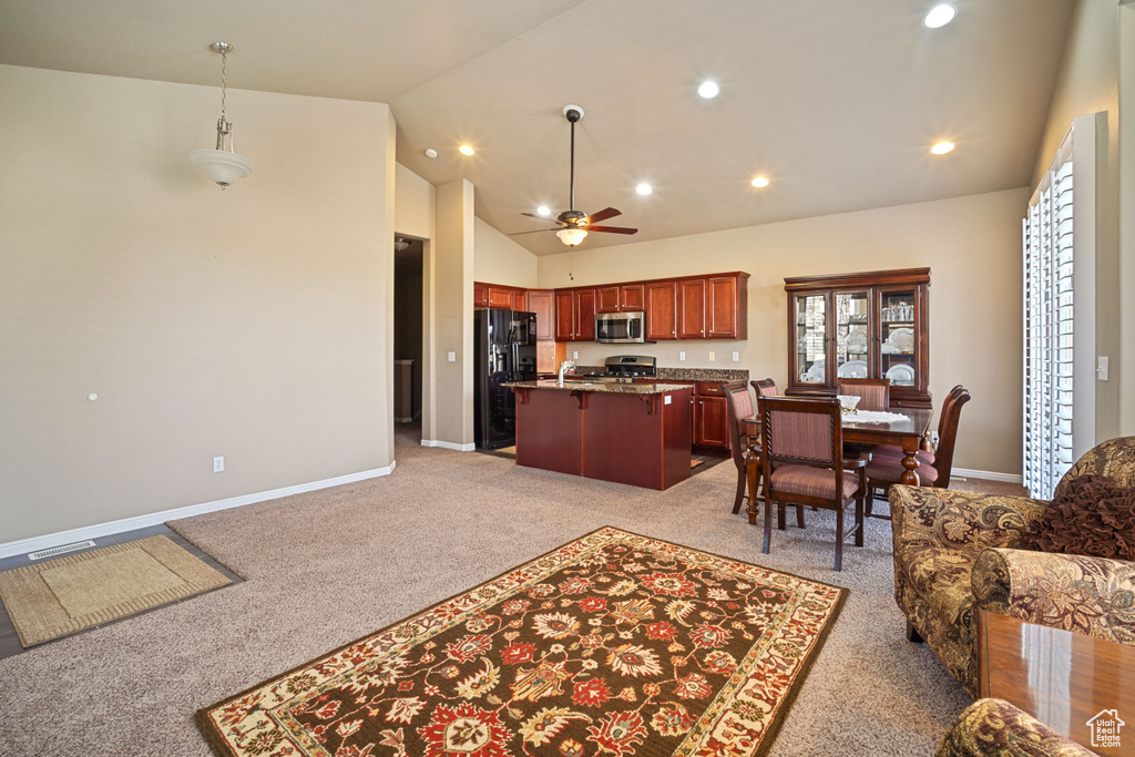 Kitchen with light carpet, decorative light fixtures, a kitchen bar, and a wealth of natural light