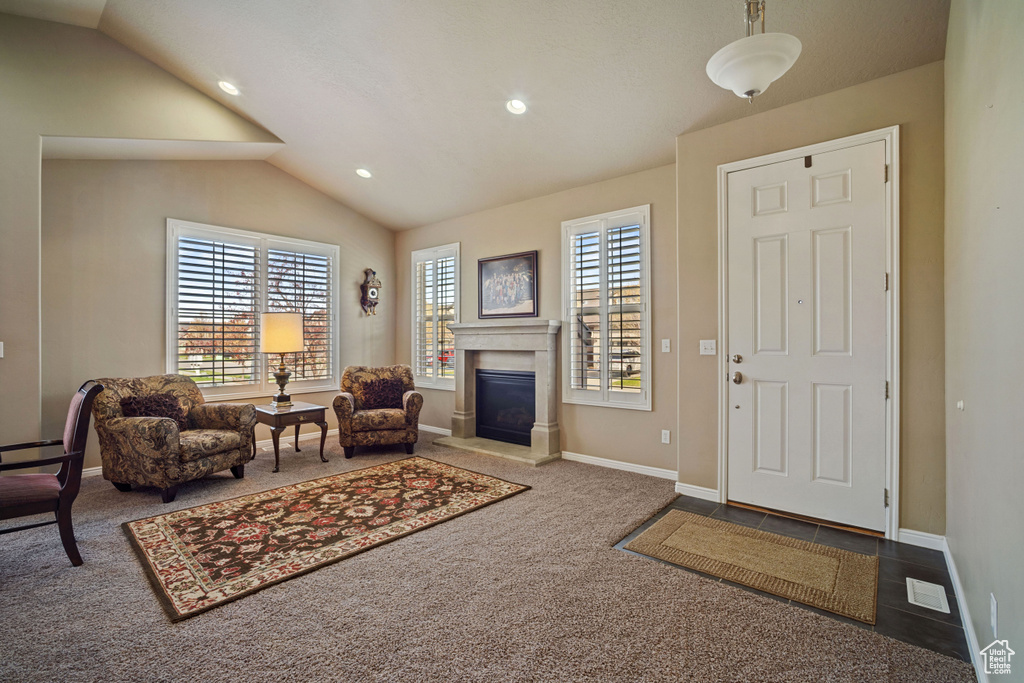 Living room with plenty of natural light, carpet, and vaulted ceiling
