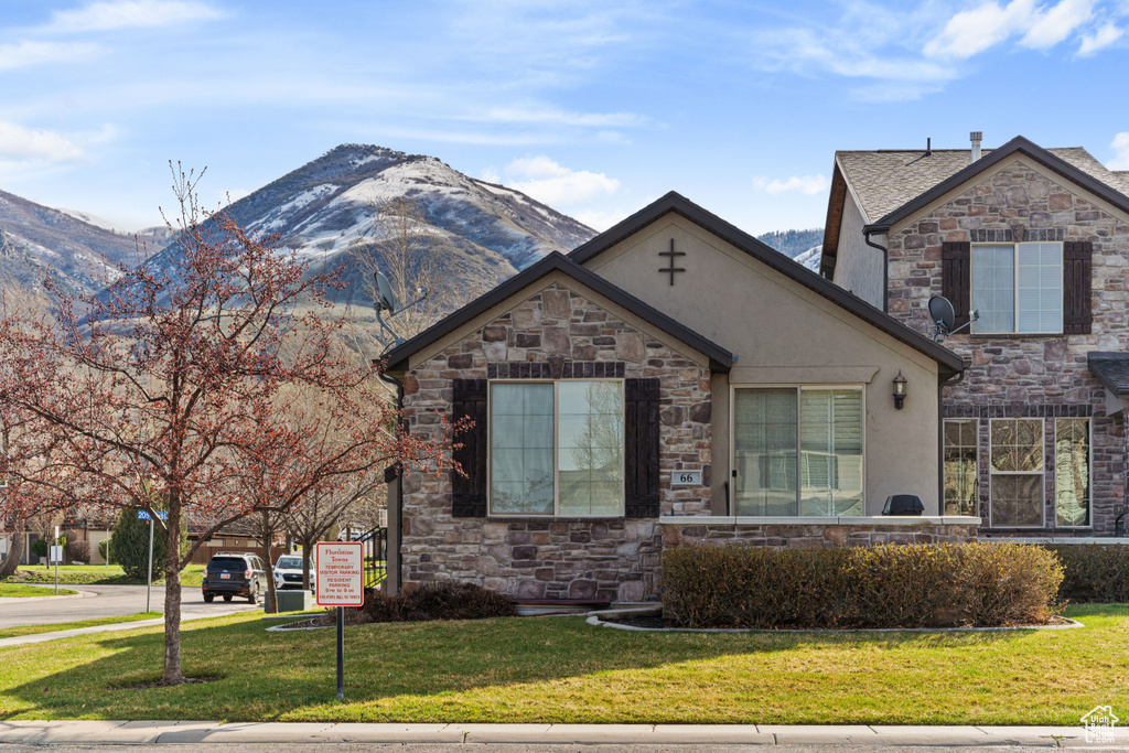 View of front of house with a front lawn and a mountain view