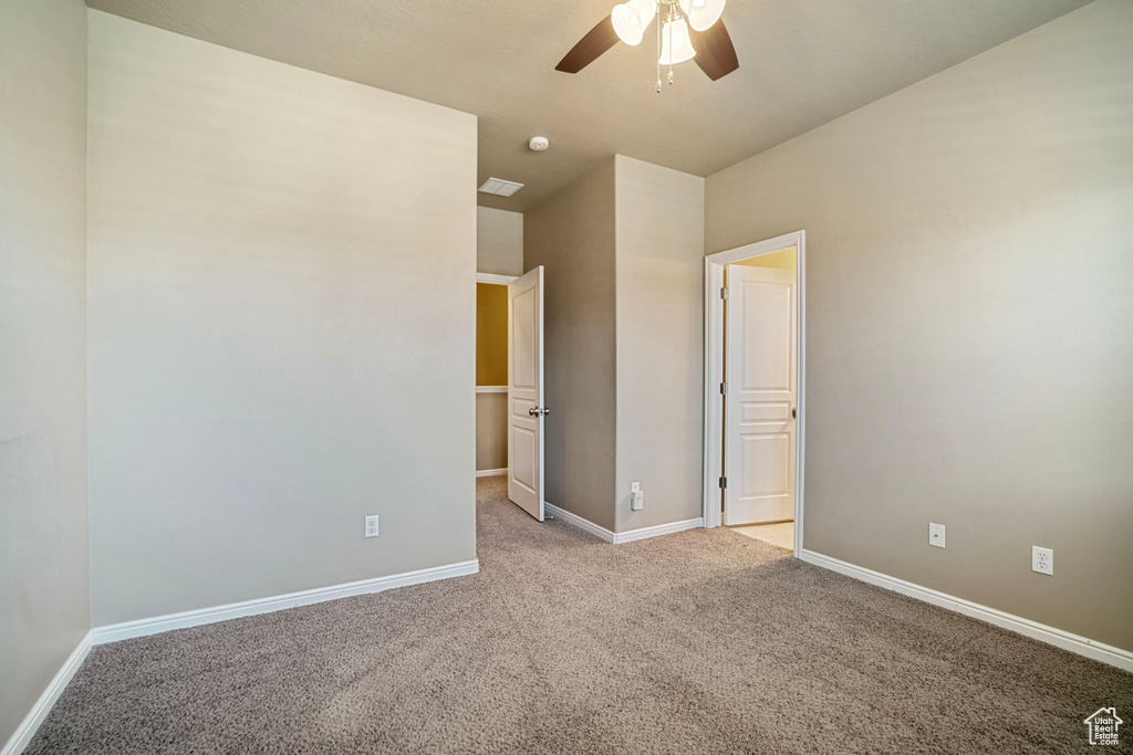 Unfurnished bedroom with light colored carpet and ceiling fan
