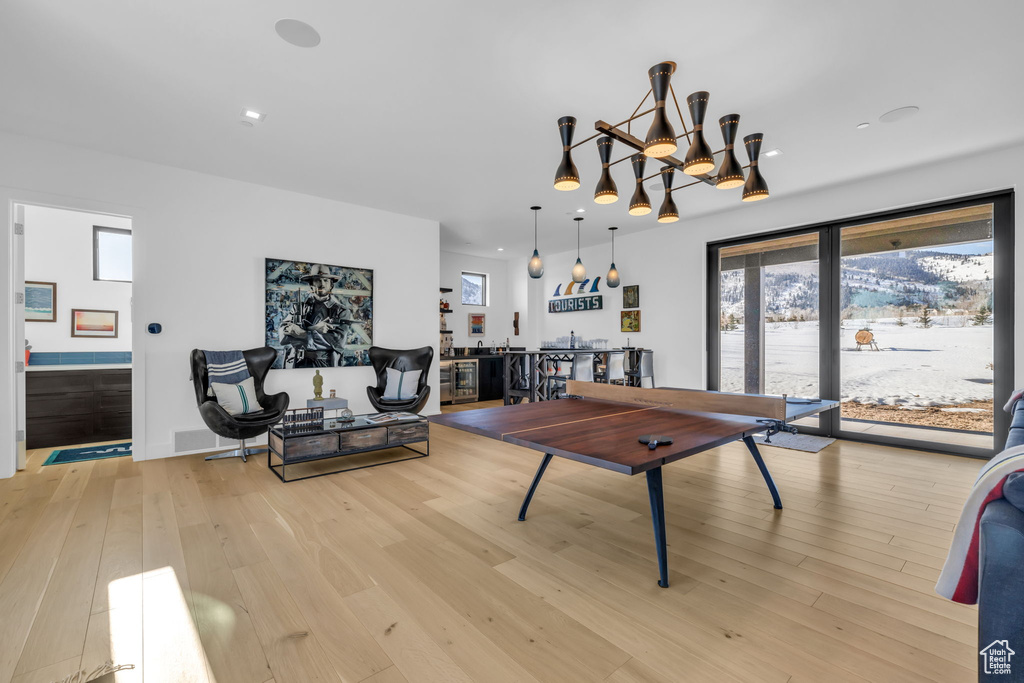 Recreation room featuring light hardwood / wood-style floors and an inviting chandelier
