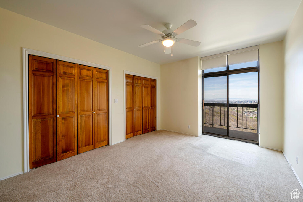 Unfurnished bedroom featuring light colored carpet, ceiling fan, and access to exterior