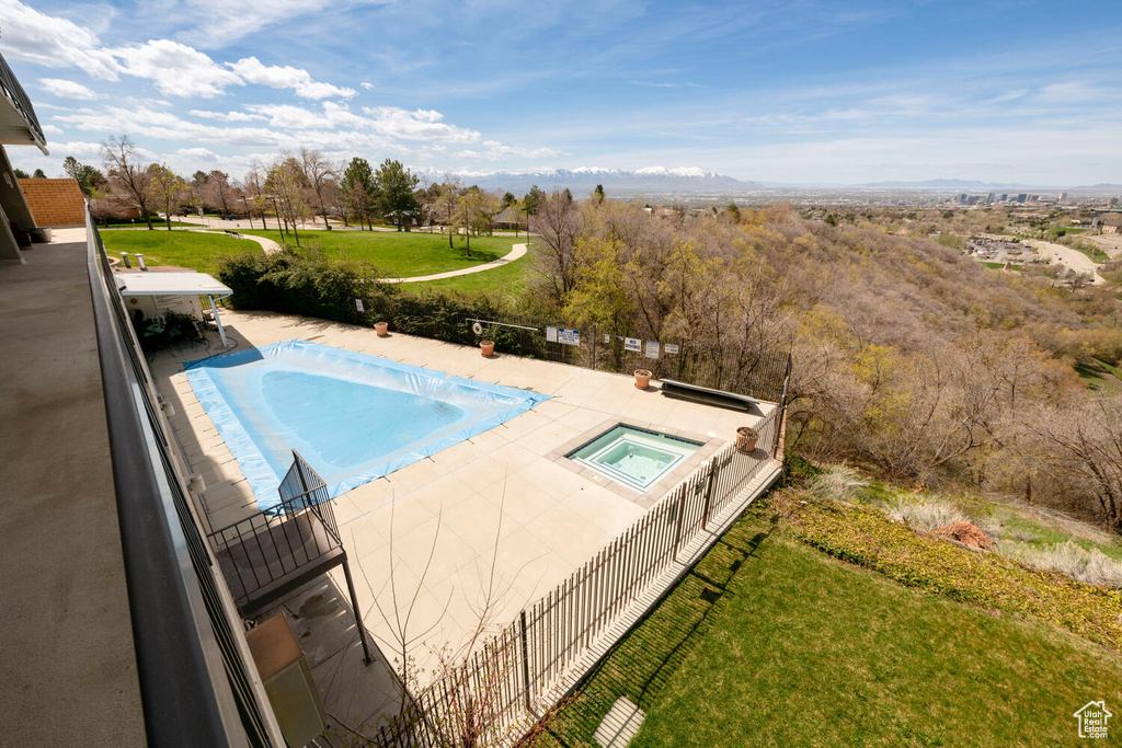 View of pool with a lawn and an in ground hot tub