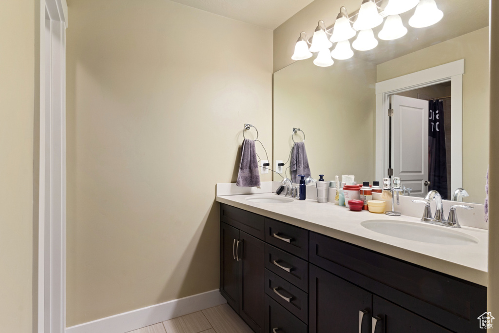 Bathroom featuring oversized vanity, tile floors, and dual sinks