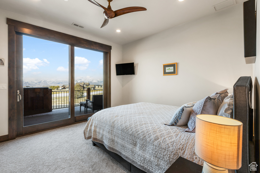 Carpeted bedroom featuring ceiling fan and access to exterior