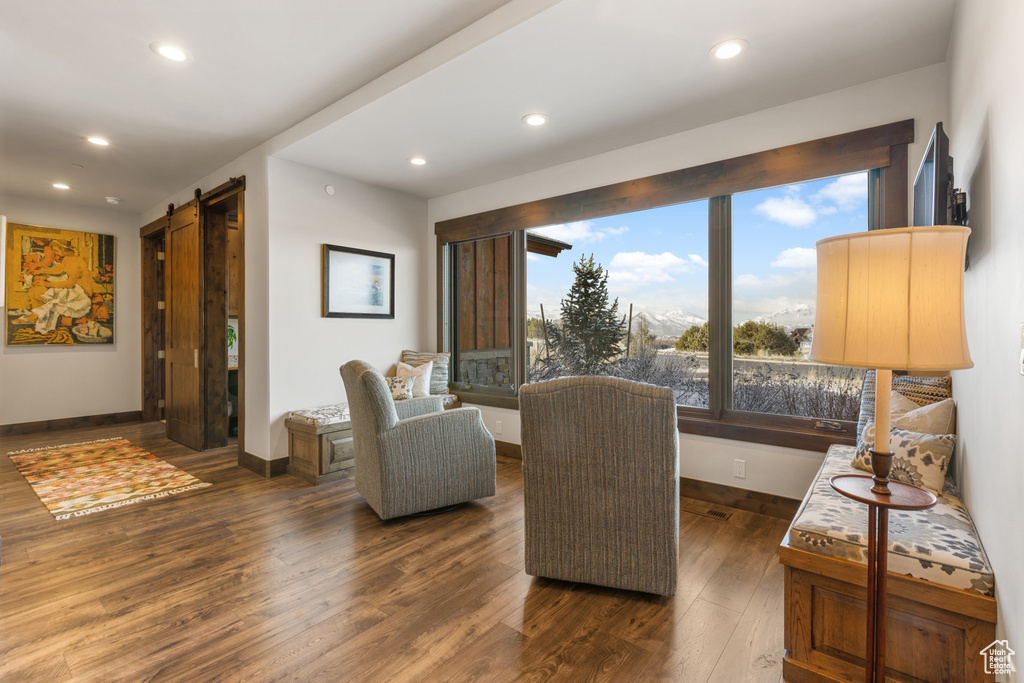 Living room featuring a barn door and dark hardwood / wood-style flooring