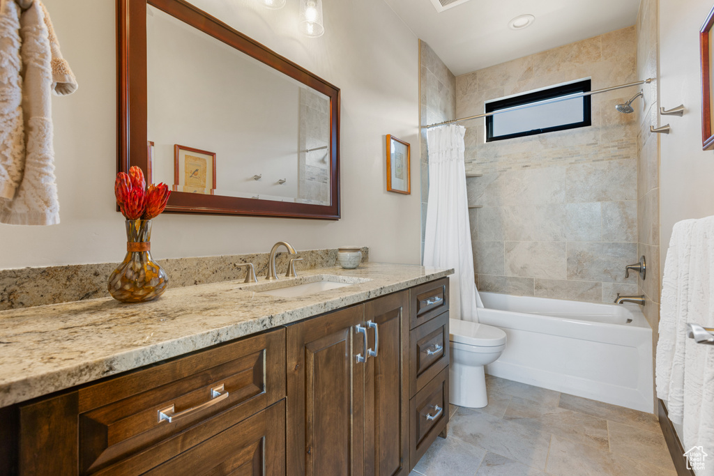 Full bathroom featuring toilet, tile flooring, shower / bathtub combination with curtain, and vanity