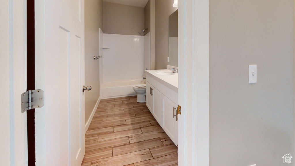 Full bathroom featuring shower / bathtub combination, toilet, hardwood / wood-style floors, and vanity