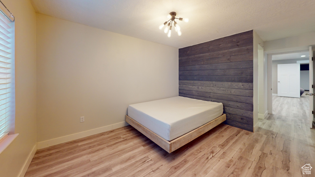 Bedroom with light hardwood / wood-style flooring and a chandelier